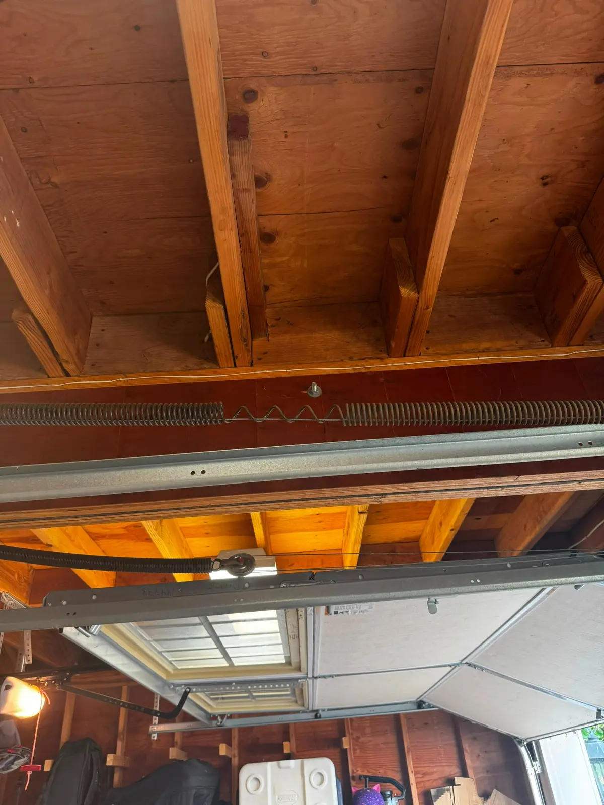 Close view of a garage door torsion spring separated in the middle above the door