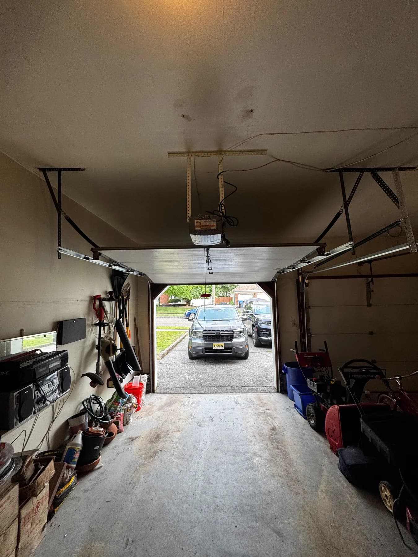 Frayed garage door lift cable strands near track