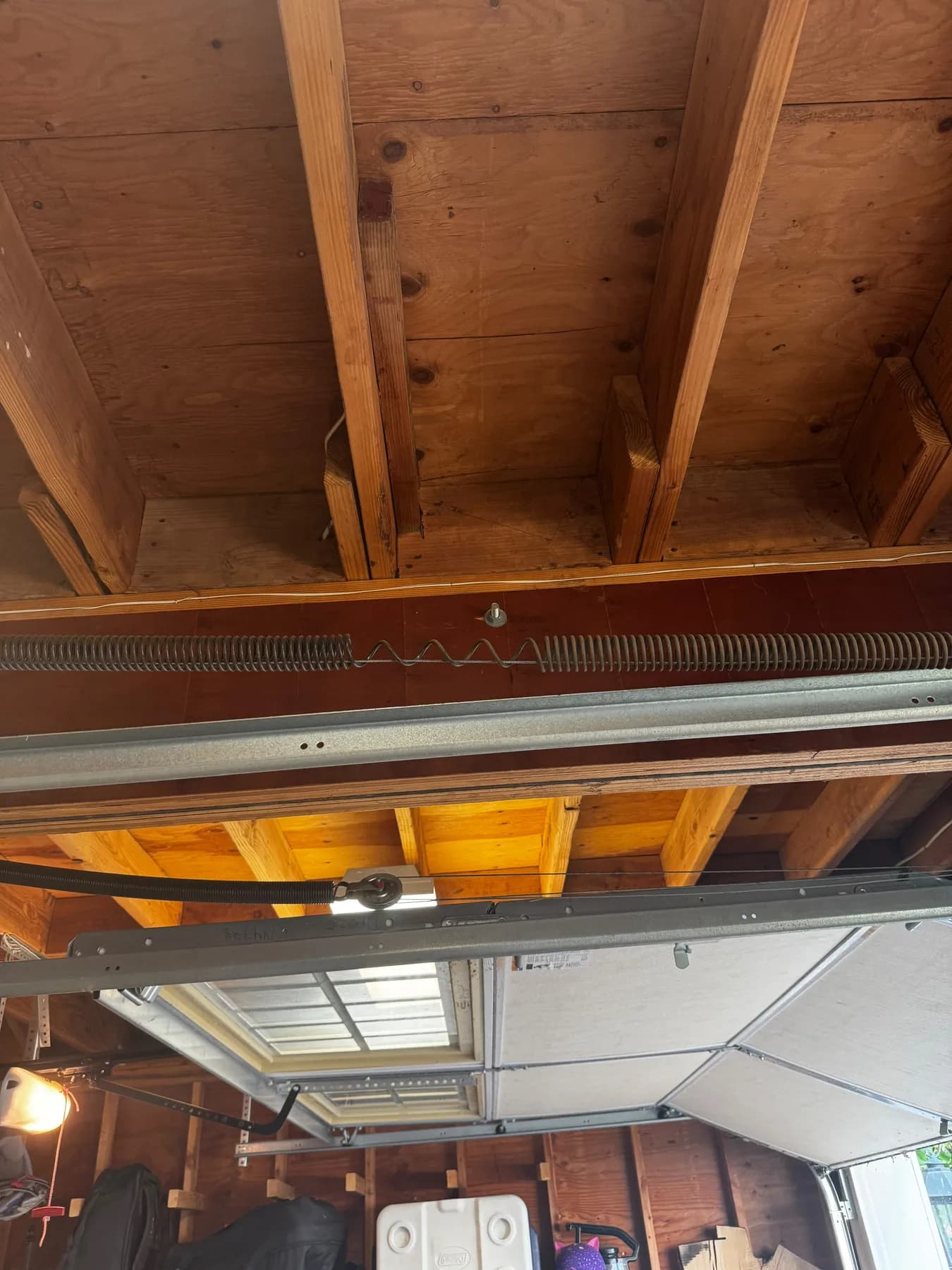 Broken torsion spring separated above a garage door