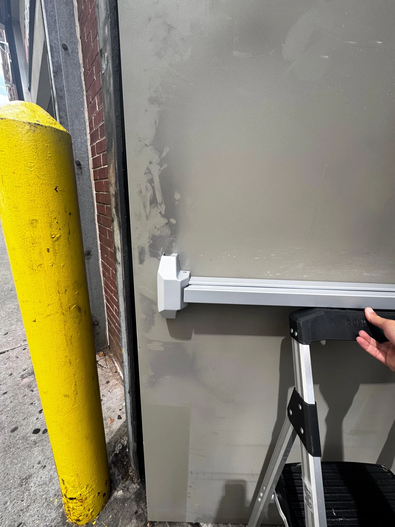 Metal exit door push bar installed
