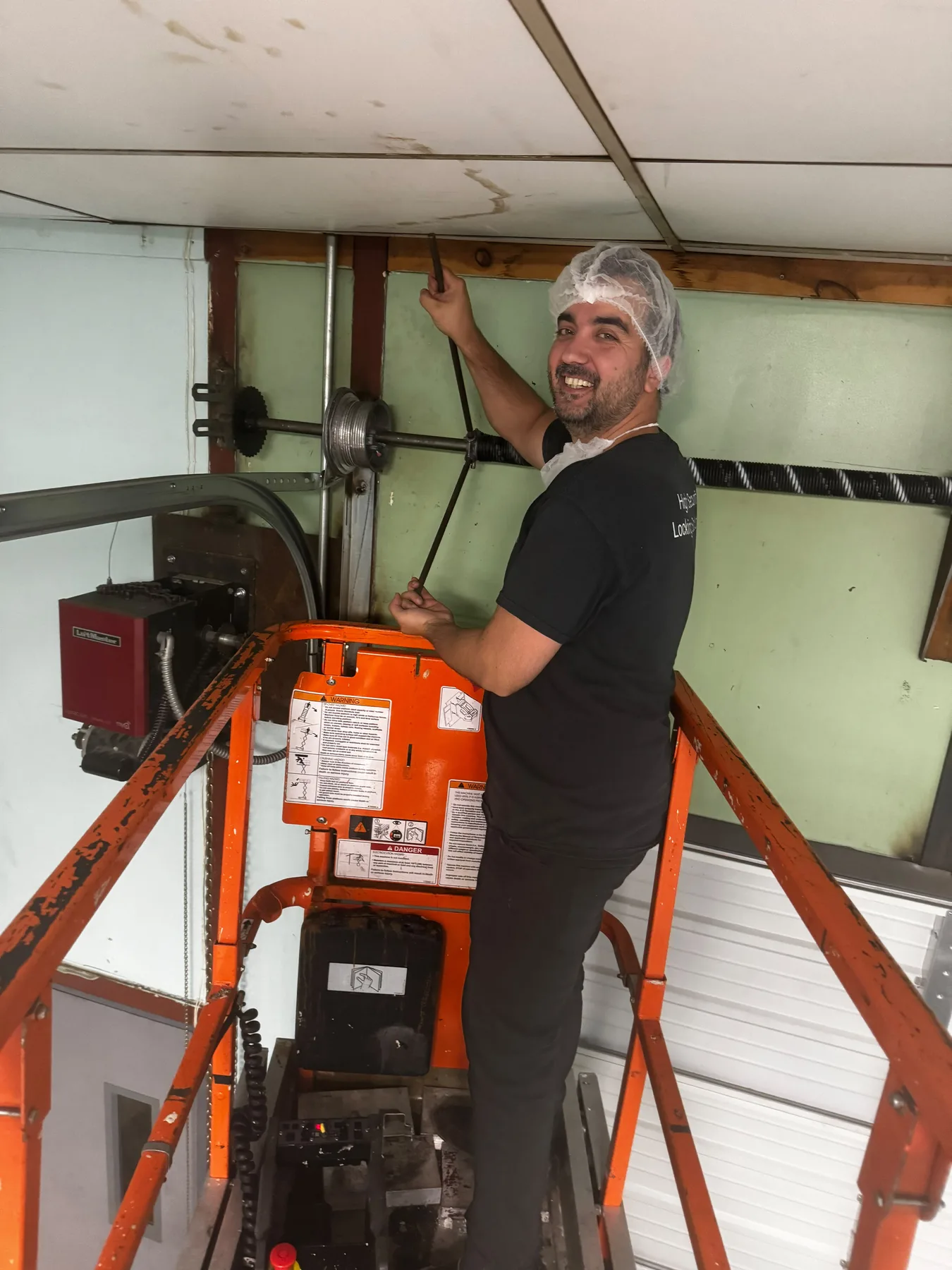 Garage door technician adjusting springs